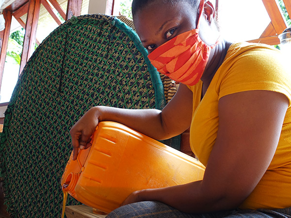 Agnes sieving Madugu’s honey from bees and wax 